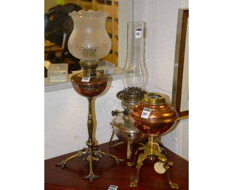An antique copper oil lamp, with frilly glass light shade above copper reservoir, raised on ornate brass stand, together with