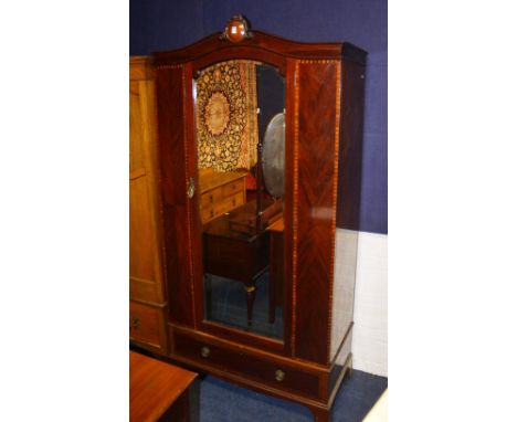 An early 20th century mahogany inlaid mirror door wardrobe, with moulded cornice above mirror door and single drawer, ending 