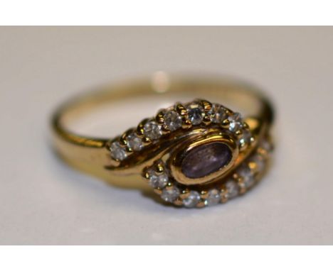 A 9ct gold amethyst and diamond ring, the central oval cut amethyst surmounted by 16 mili diamonds (approx .16ct in total, ap