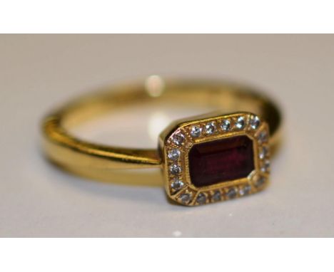 An 18ct gold ruby and diamond ring, the central baguette cut ruby surmounted 18 mili diamonds, (ring size N), 4.2g CONDITION 