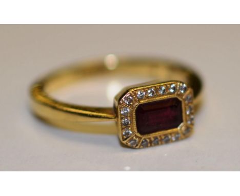 An 18ct gold ruby and diamond ring, the central baguette cut ruby surmounted 18 mili diamonds, (ring size N), 4.2g CONDITION 