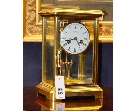 A brass mantle clock by Duchateau, the moulded cornice over glass case enclosing white face with Roman numerals, mercury fill