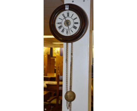 An early 20th century mahogany framed circular wall clock, the white enamel dial with black Roman numerals, with pendulum, 29