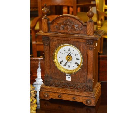 A late Victorian patent automatic alarm clock, by Fattorini & Sons, cased in oak, no.16226, with white enamel dial, 41cm high