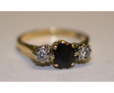 An 18ct gold sapphire and diamond ring, the central oval cut sapphire surmounted by two round cut diamonds set within illusio