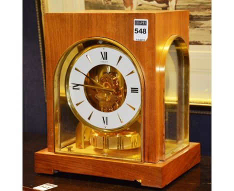 A Gruen Atmos clock, the white and gilt enamel dial with gilt baton numerals, within a walnut casing, 16cm high CONDITION REP
