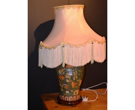 An Oriental ceramic table lamp with shade decorated with symbols in foliage on a green ground, 85cm high