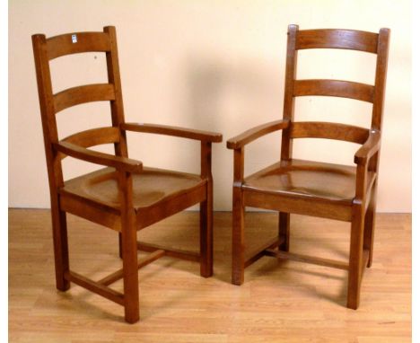 A pair of oak kitchen armchairs, with ladder backs, shaped arm rests and solid seats, 110cm high x 59cm wide