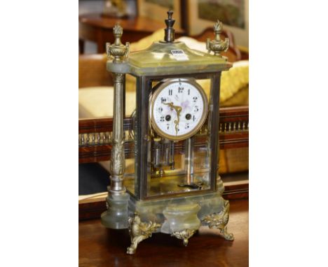 A late 19th / early 20th century onyx mantle clock, decorated with gilt metal Athena style mounts, and white enamel circular 