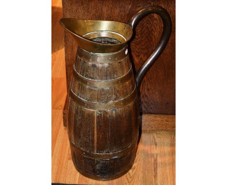 A large oak and brass bound jug, possibly for stick stand purposes, with shaped copper handle, 63cm high CONDITION REPORT: Lo