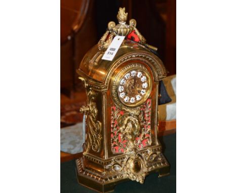 A late 19th century French brass mantle clock, with urn finial and wreaths, with moulded arched pediment, circular face with 