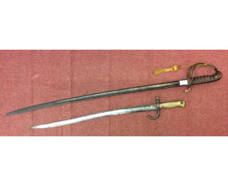 A French Chassepot bayonet with Yataghan fullered blade, 22.75 inch, and ribbed brass grip, scrolled quillon and muzzle ring,