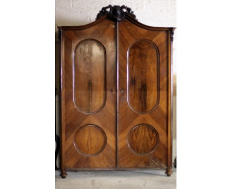 An attractive 19th Century two door French walnut Wardrobe, with shape top and carved capital over two inverted panel doors, 