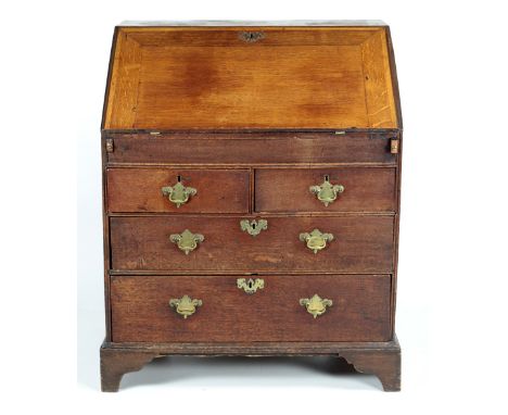 A 19th Century oak Bureau, with slope front and fitted interior, over two short and two long drawers with brass handles on br