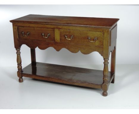 A small oak Dresser Base / Sideboard, the rectangular top with moulded edge, over two plain oak frieze drawers, brass handles