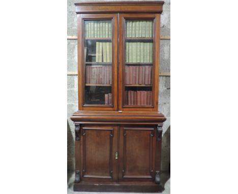 An elegant early Victorian period mahogany Bookcase, the figured cornice over two glazed doors, a moulded frieze with blind d