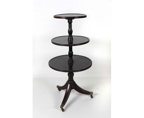 A George III circular mahogany Dumbwaiter, with three graduating shelves on a tripod base with brass castors, 120cms (47") hi