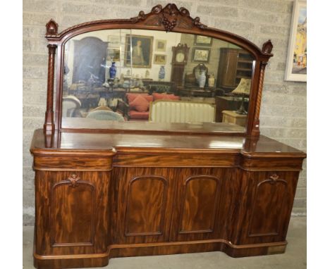 A good quality early Victorian figured mahogany inverted breakfront Sideboard, the carved back with large mirror plate, over 