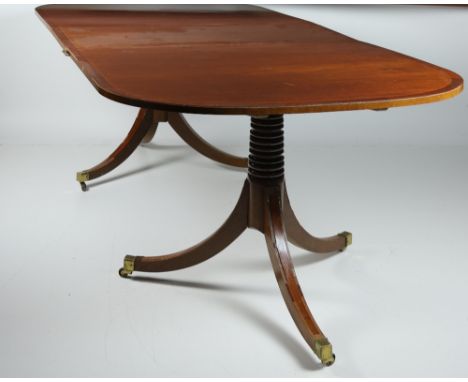 A Georgian style mahogany extending tripod Dining Table, with crossbanded top over pillar supports with outsplayed legs, with