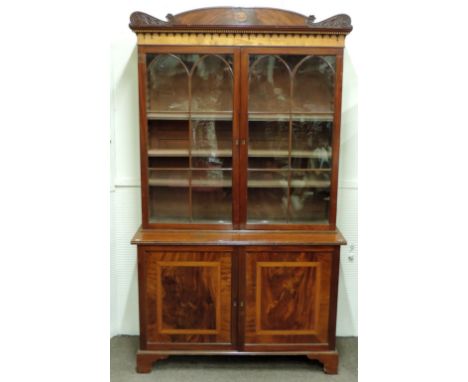 A fine George III period mahogany Bookcase, the attractive inlaid and carved cornice with satinwood panel, over a large top e