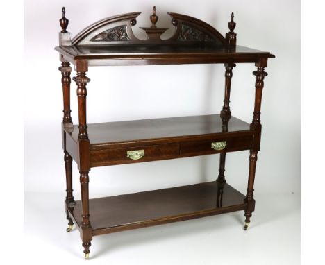 An attractive 19th Century Irish mahogany three tier Dumbwaiter, with carved arch back flanked with finials, supported by tur