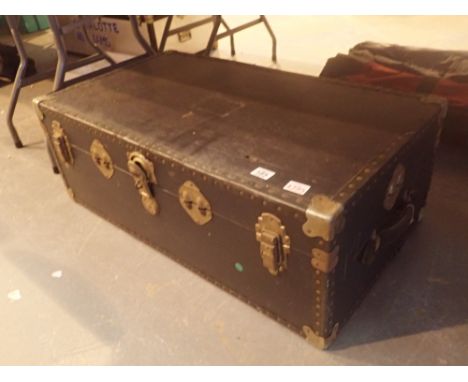 Large black storage trunk with metal fittings and corner braces and leather handle