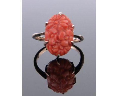 A 9ct gold ring set with a floral carved coral mount,coral 15mm x 10mm, size M.