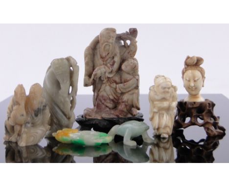 A carved ivory head,1.7", ivory netsuke, carved stone group of two figures on wooden stand, etc.