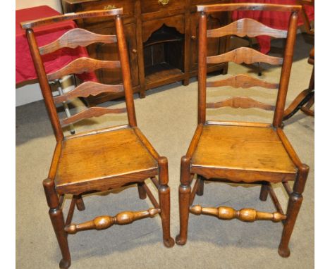 A pair of early 19th century elm chairs with ladder backs and turned legs.