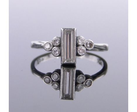 A platinum diamond set ring,with central 8mm baguette diamond and small diamond set shoulders, size K.