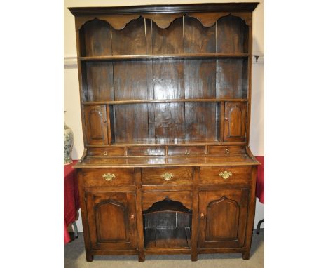 A Georgian style elm dresser,with boarded open plate-rack, cupboards and spice drawers, the base fitted with 3 frieze drawers