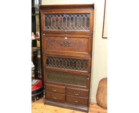 Globe Wernicke style oak stacking bookcase having three leaded glazed doors a fall front and four drawers 