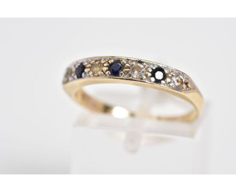 A 9CT GOLD HALF ETERNITY RING, set with three circular cut sapphires interspaced with four circular cut colourless stones ass
