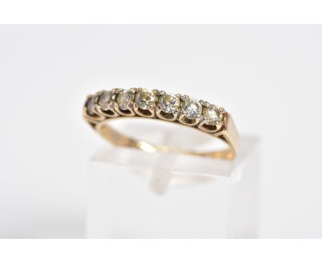 A 9CT GOLD CUBIC ZIRCONIA HALF ETERNITY RING, designed with seven claw set circular cut cubic zirconia, to the plain polished