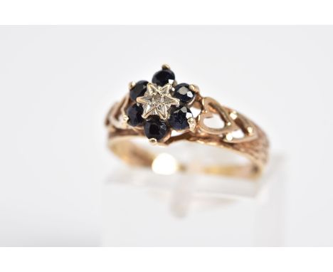 A 9CT GOLD SAPPHIRE AND DIAMOND CLUSTER RING, the cluster set with a single cut diamond within a circular cut sapphire surrou