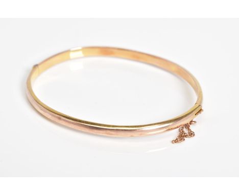A 9CT GOLD HINGED BANGLE, the plain polished hollow bangle with push pin clasp and safety chain, with a 9ct hallmark for Birm