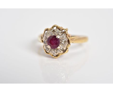 A RUBY AND DIAMOND CLUSTER RING, designed with a central circular cut ruby with single cut diamond surround, openwork scallop