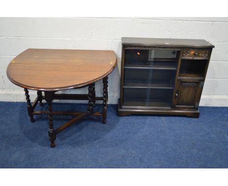 AN OAK BARLEY TWIST OVAL TOPPED GATE LEG TABLE, and an oak double sliding bookcase with a single drawer (2)