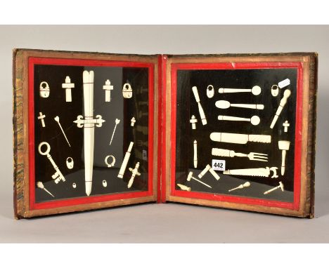 PRISONER OF WAR BONE CARVINGS, a collection of 19th Century carvings housed in a hinged book shaped display case with marble 