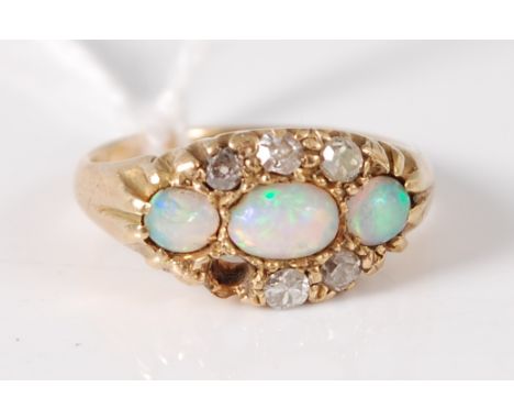An 18ct gold, opal and diamond ring, arranged as three cabochon opals flanked to either side with three old cut diamonds (one