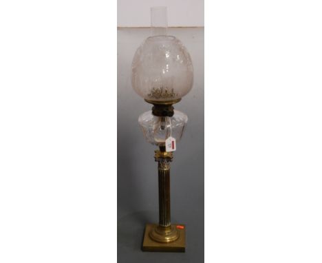 A Victorian oil lamp, having etched glass shade above a clear glass font, raised on a brass Corinthian column and square base