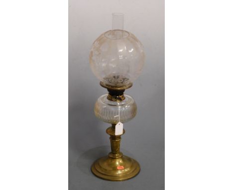 A Victorian oil lamp, having etched globular glass shade above a clear glass font, on brass pedestal base, h.53cm