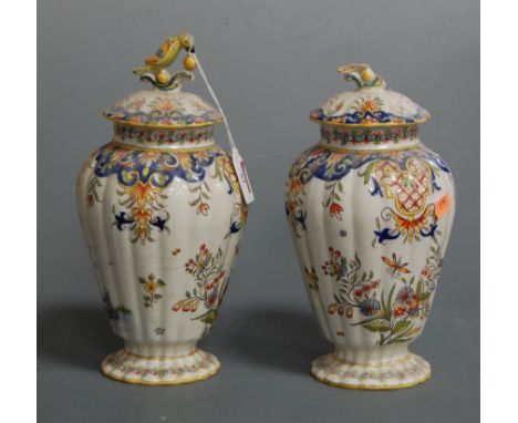 A pair of late 19th century continental faience vases and covers, each of fluted baluster form decorated with windmill and sa