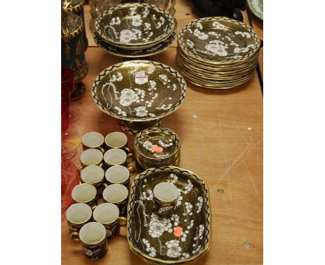 An early 20th century Maling coffee/dessert service on a black ground, heightened in gilt with white floral decoration, print