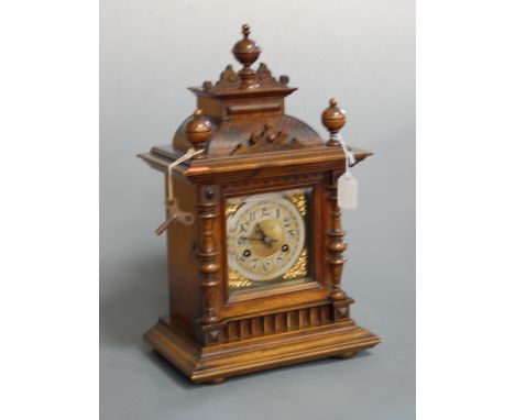 A late 19th century continental walnut cased mantel clock having an engraved chapter ring with Arabic numerals, eight day mov