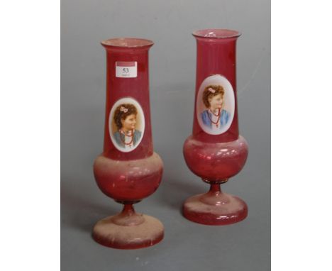 A pair of early 20th century cranberry glass vases, each of tapered cylindrical form to a bulbous lower body and circular foo