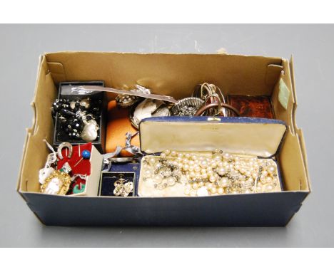 A box of miscellaneous items to include faux pearl necklaces, shell carved cameo brooch, horseshoe brooch, baby's rattle etc