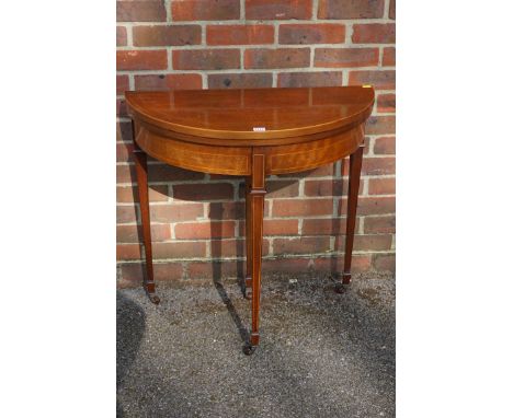 An Edwardian mahogany and line inlaid demi lune card table, 76.5cm wide.&nbsp; 