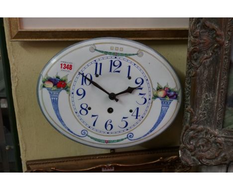 An unusual continental enamel wall clock,&nbsp;31.5cm wide, with pendulum.&nbsp; 