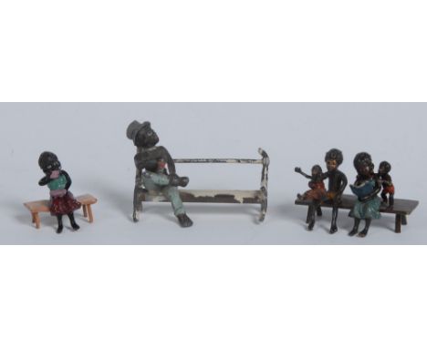 An early 20th century cold painted spelter model, cast as a black man at rest on a bench, scantily dressed in top hat and tro